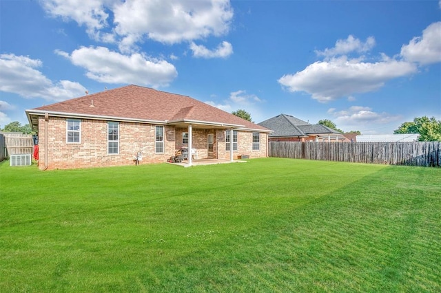 back of house featuring cooling unit, a yard, and a patio