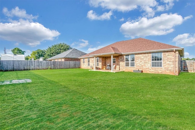 rear view of house with a patio and a lawn