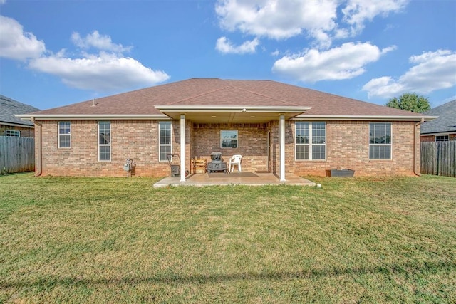 rear view of property featuring a patio area and a lawn