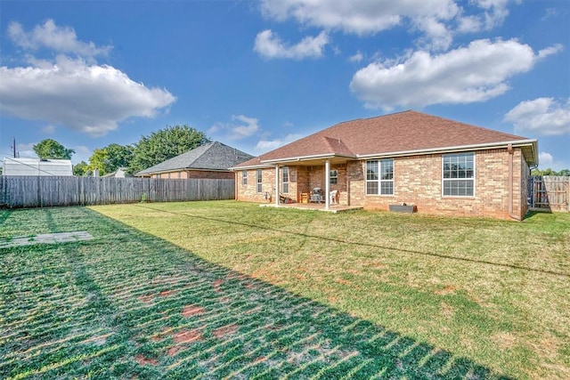 rear view of house with a yard and a patio