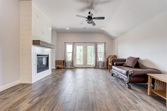 living room featuring dark hardwood / wood-style floors, ceiling fan, lofted ceiling, and a fireplace