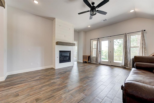 living room featuring hardwood / wood-style floors, a large fireplace, ceiling fan, and lofted ceiling