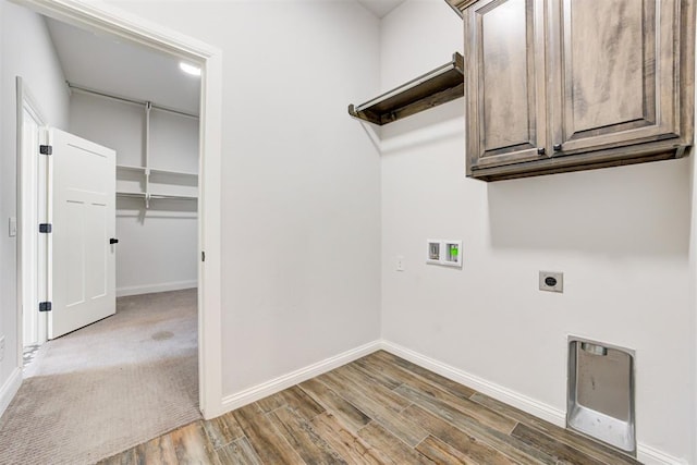 laundry room with electric dryer hookup, cabinets, hookup for a washing machine, dark hardwood / wood-style floors, and heating unit