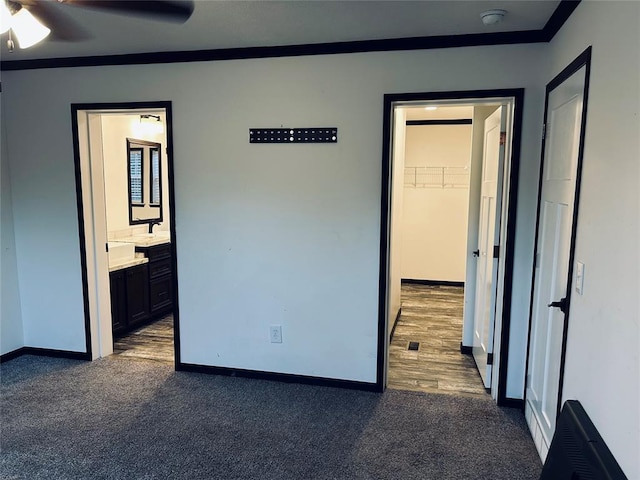 unfurnished room with ceiling fan, dark carpet, and ornamental molding