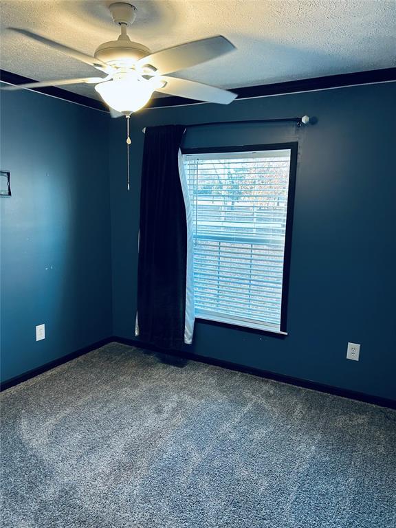 carpeted empty room with a textured ceiling and ceiling fan