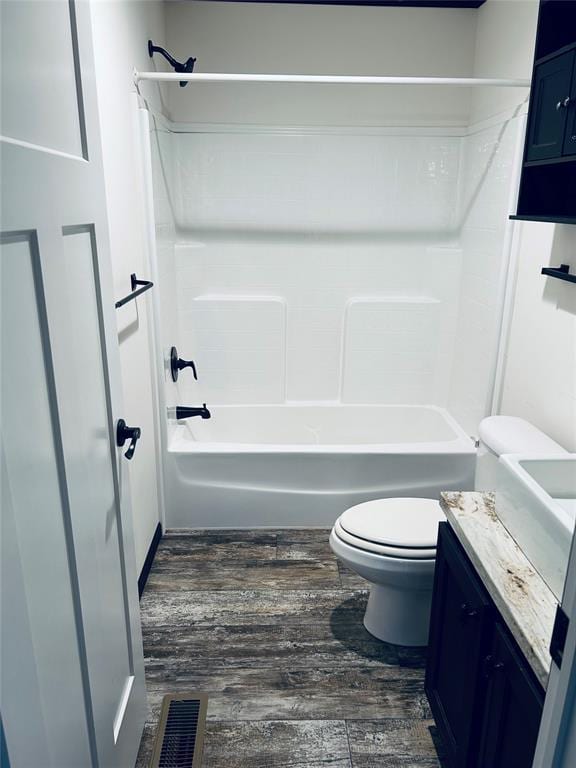 full bathroom featuring hardwood / wood-style floors, vanity,  shower combination, and toilet