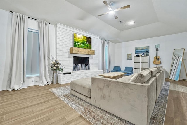 living room featuring a fireplace, ceiling fan, and hardwood / wood-style floors