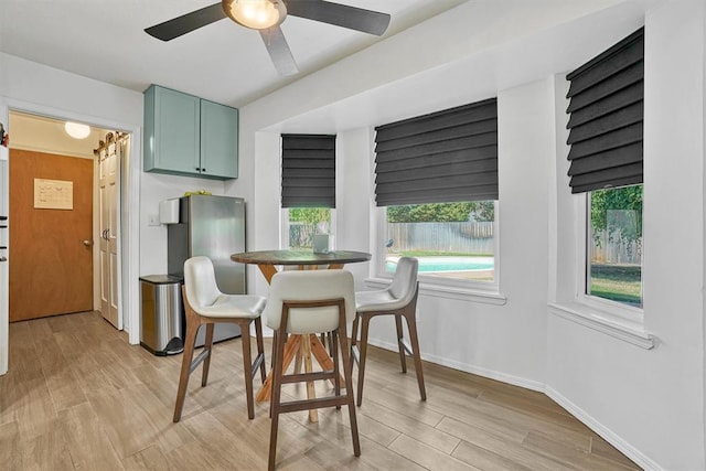 dining space with light wood-type flooring and ceiling fan