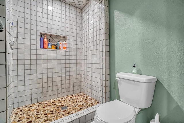 bathroom with toilet and tiled shower