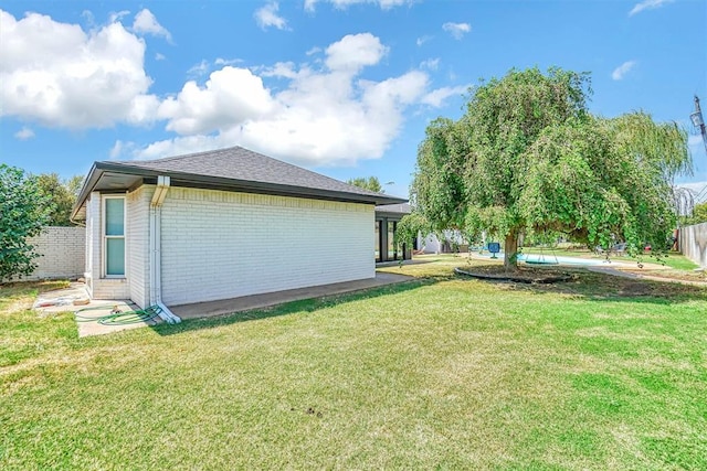 view of side of home with a yard