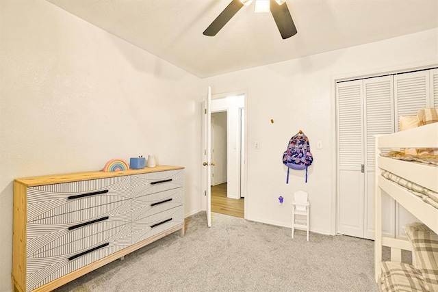 bedroom with ceiling fan, light colored carpet, and a closet