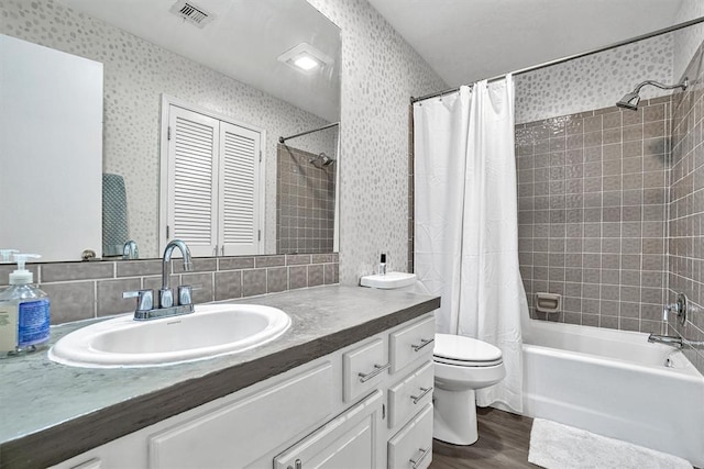 full bathroom featuring hardwood / wood-style flooring, vanity, toilet, and shower / tub combo with curtain