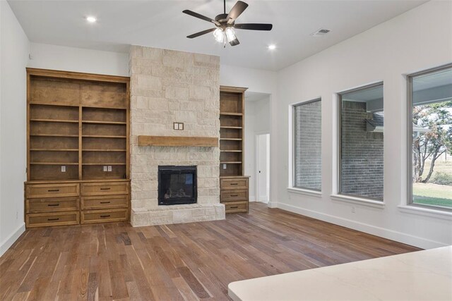 unfurnished living room featuring a wealth of natural light, a fireplace, and wood-type flooring