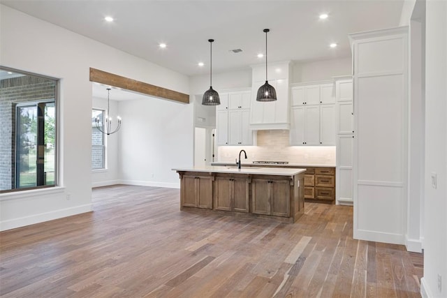 kitchen with a large island, white cabinets, and light wood-type flooring