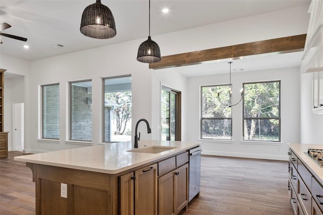 kitchen featuring wood-type flooring, hanging light fixtures, and an island with sink