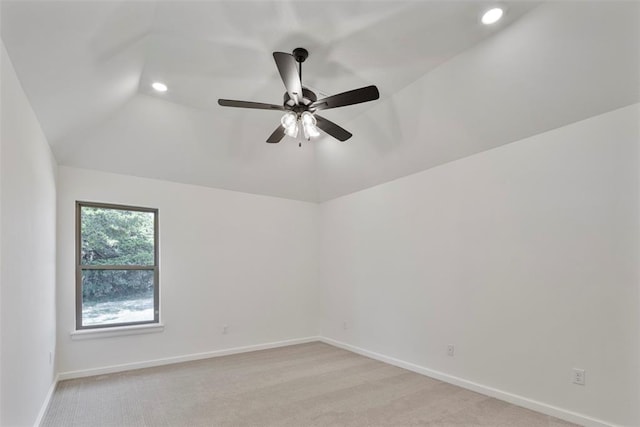 spare room featuring ceiling fan, lofted ceiling, and light carpet