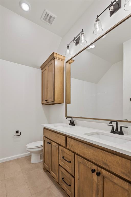 bathroom with tile patterned flooring, vanity, and toilet