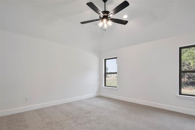 unfurnished room with ceiling fan, light colored carpet, and lofted ceiling