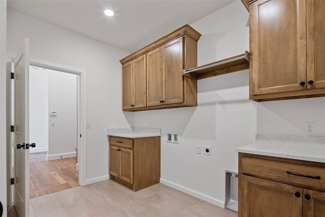 laundry area with electric dryer hookup, light hardwood / wood-style flooring, cabinets, and washer hookup