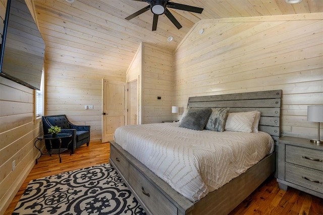 bedroom with vaulted ceiling, ceiling fan, hardwood / wood-style flooring, wooden ceiling, and wood walls