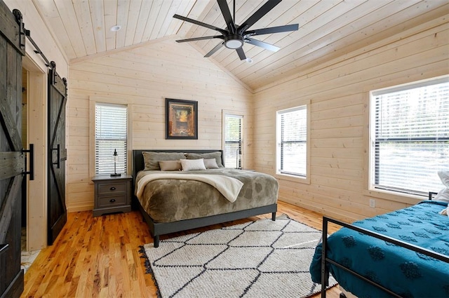 bedroom with light hardwood / wood-style floors, vaulted ceiling, multiple windows, and ceiling fan