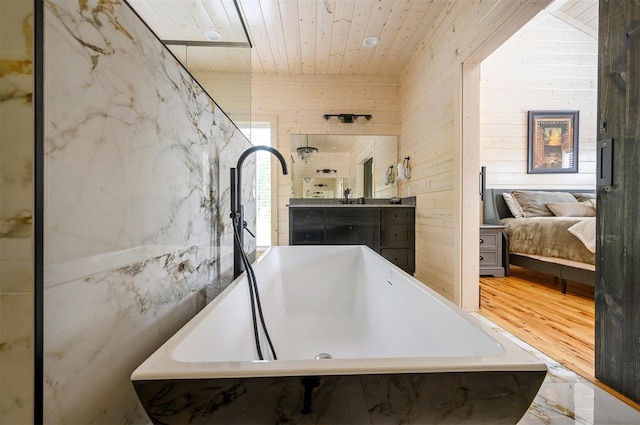 bathroom with a bathing tub, wood-type flooring, wooden walls, vanity, and wood ceiling