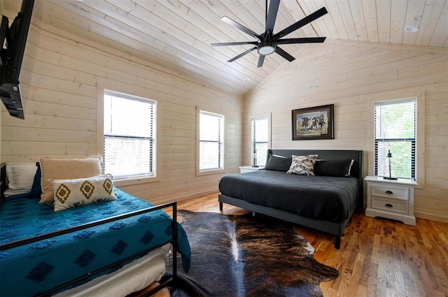 bedroom featuring high vaulted ceiling, wooden walls, light hardwood / wood-style flooring, ceiling fan, and wood ceiling