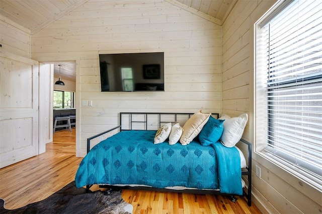 bedroom featuring hardwood / wood-style floors, wood walls, wood ceiling, and vaulted ceiling