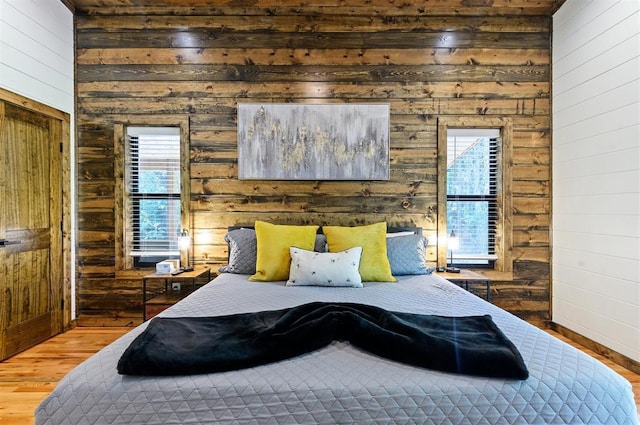 bedroom with wood-type flooring and wood walls