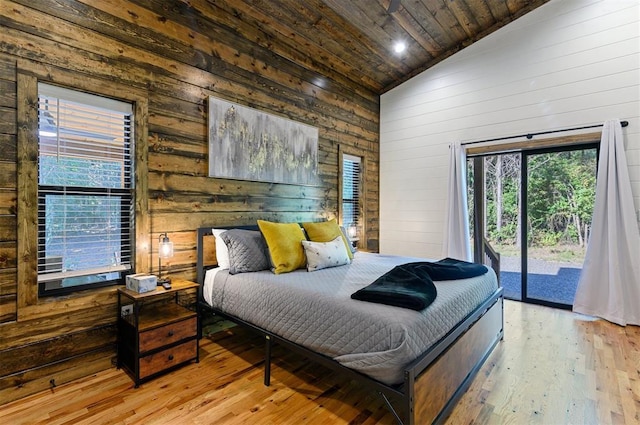 bedroom featuring wooden walls, wooden ceiling, access to outside, and light hardwood / wood-style flooring