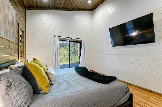 bedroom featuring lofted ceiling, wooden ceiling, wooden walls, hardwood / wood-style flooring, and access to exterior