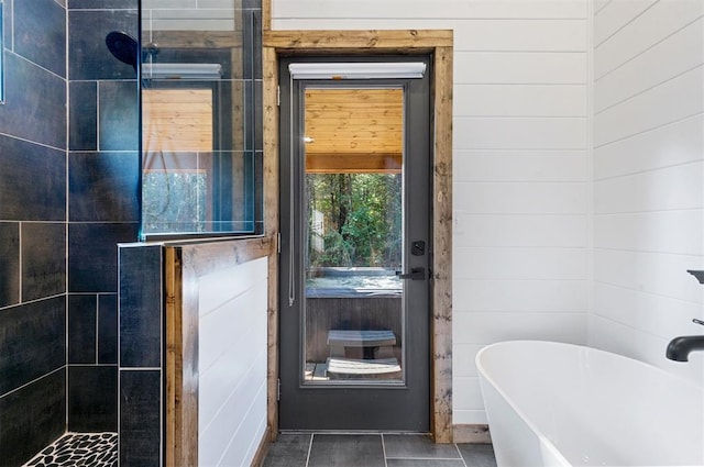 bathroom with plus walk in shower, tile patterned flooring, and wood walls