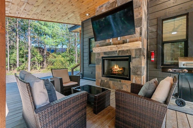 exterior space featuring an outdoor stone fireplace and a wooden deck