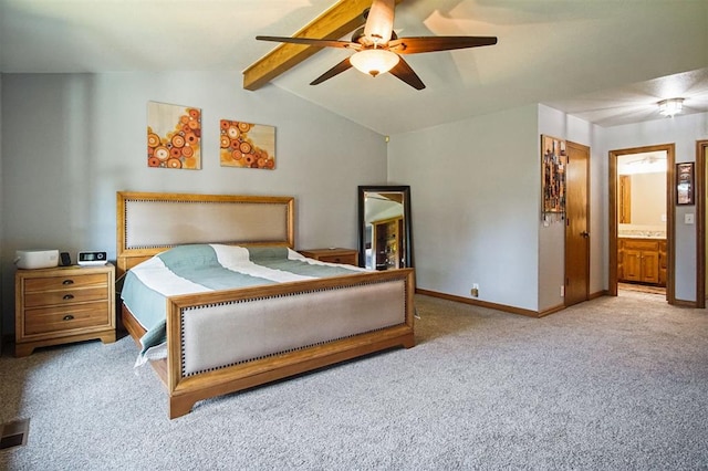 carpeted bedroom with ensuite bath, ceiling fan, and vaulted ceiling with beams