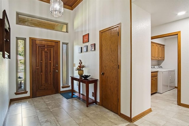 foyer with washing machine and dryer and a chandelier