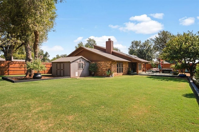 back of house featuring a lawn, a patio, and a storage unit