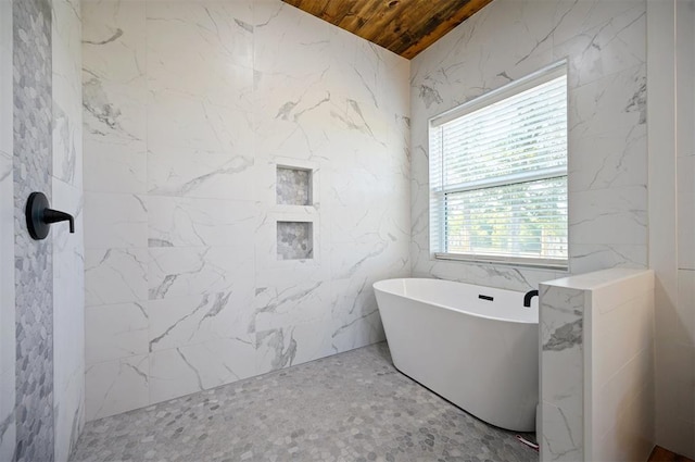 bathroom with tile walls, a tub, and wood ceiling