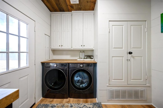 washroom featuring separate washer and dryer, cabinets, wooden ceiling, and light hardwood / wood-style floors