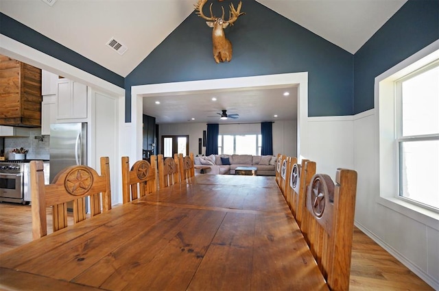 dining room featuring a wealth of natural light, ceiling fan, lofted ceiling, and light wood-type flooring