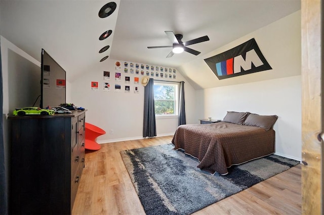 bedroom with ceiling fan, light wood-type flooring, and vaulted ceiling