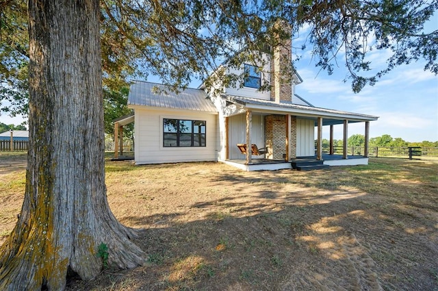 back of house featuring a porch and a lawn