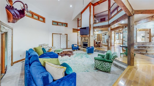 living room featuring hardwood / wood-style flooring, a fireplace, high vaulted ceiling, and beamed ceiling