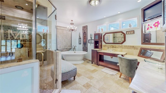 bathroom with vanity, separate shower and tub, and an inviting chandelier