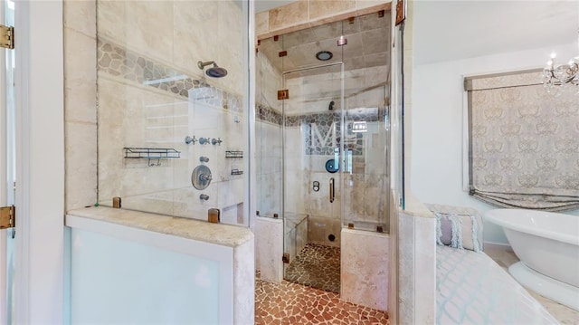 bathroom featuring a notable chandelier and shower with separate bathtub