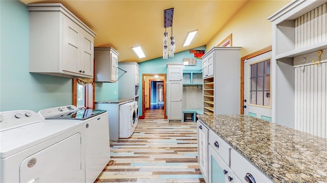 washroom with washer and clothes dryer, cabinets, and light hardwood / wood-style floors