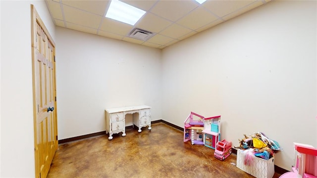 rec room with a drop ceiling and concrete floors