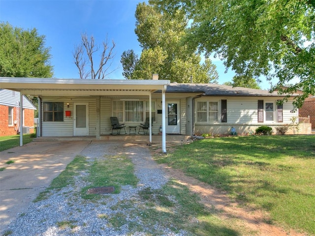 ranch-style home featuring a front lawn and a carport