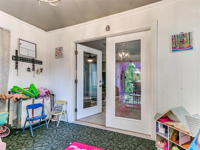 doorway with wooden walls, french doors, and a chandelier