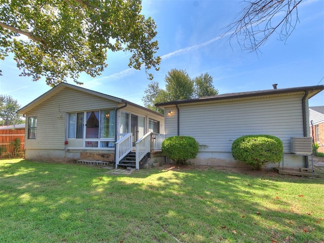 view of front of house featuring central AC unit and a front lawn