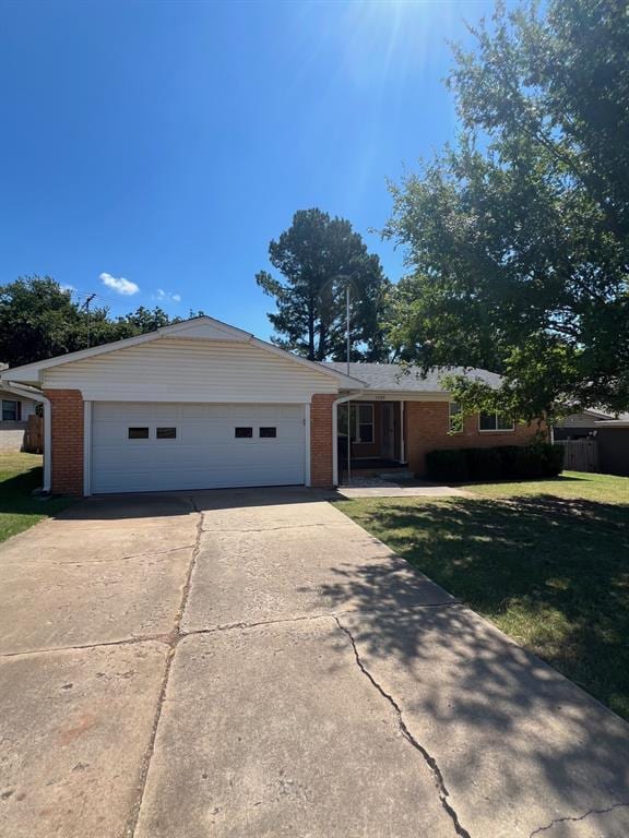 single story home featuring a front lawn and a garage